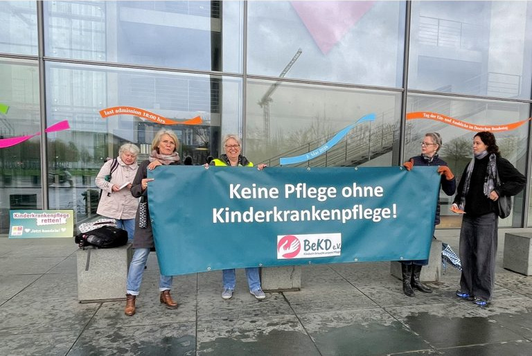 Mitglieder von BeKD und Bündnis KJG demonstrieren vor dem Deutschen Bundestag für eine qualifizierte Kinderkrankenpflege (April 2026).